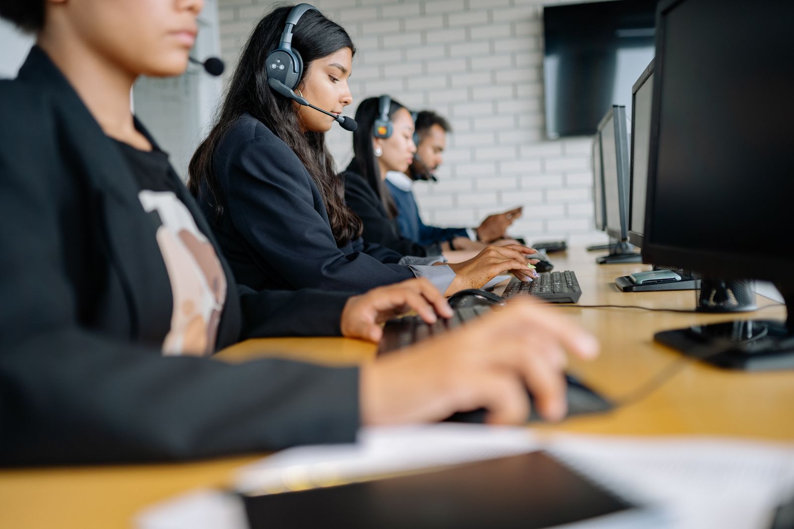 Office team working at computers with headsets